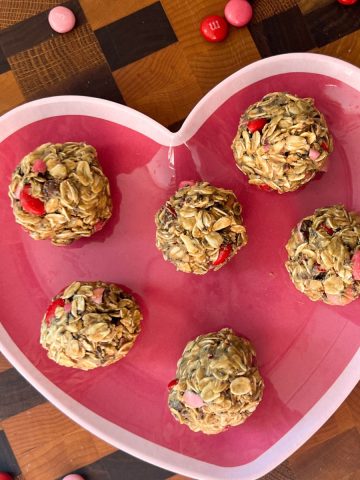 Valentine's day energy bites serving on a heart shaped plate.