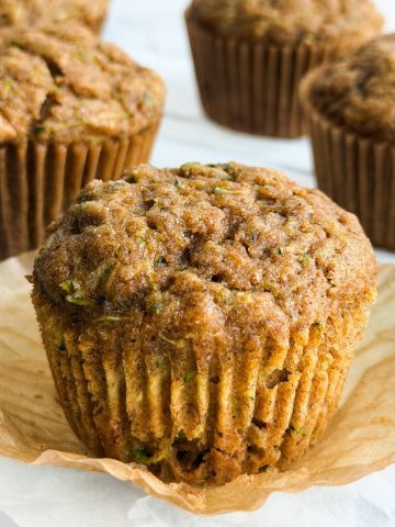 Side view of a banana zucchini muffin with the wrapper taken off.